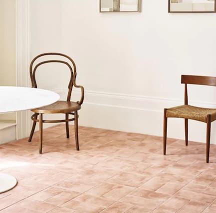 Arcilla Rose Square floor tiles in a room setting with a table and chairs